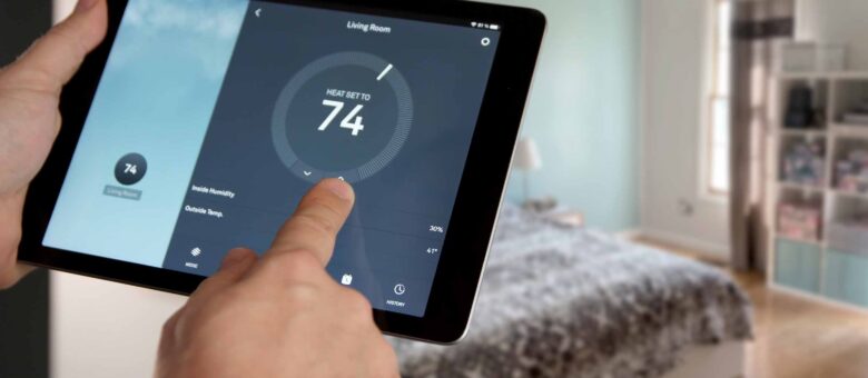 Persona ajustando la temperatura de una sala con una app en tablet.